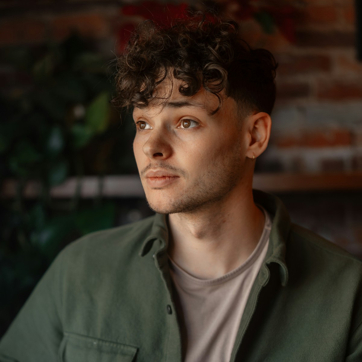 a man in a green shirt looking off into the distance